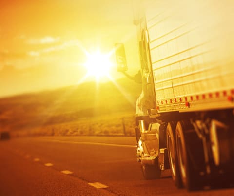 A semi truck driving in the heat